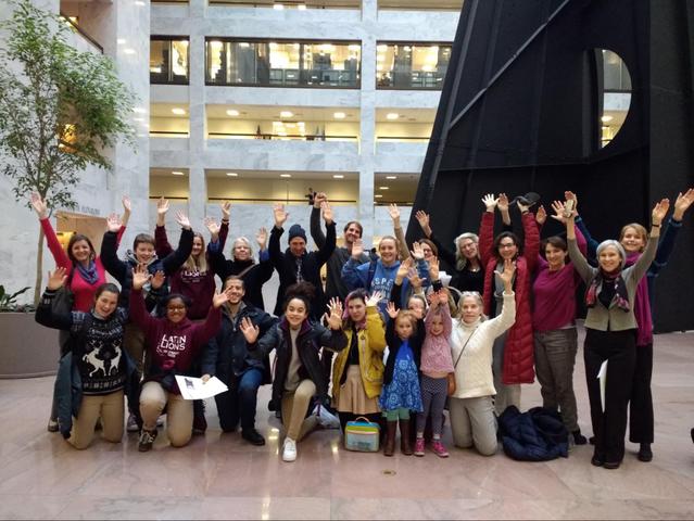 Herd on the Hill volunteers with arms raised in the atrium of the Hart Senate Office Building